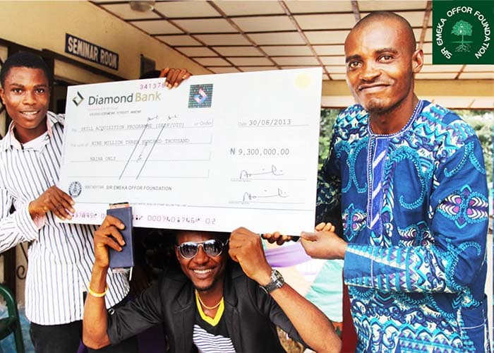 Beneficiaries of a Sir Emeka Offor Foundation award holding a presentation cheque at Oraifite, Anambra State